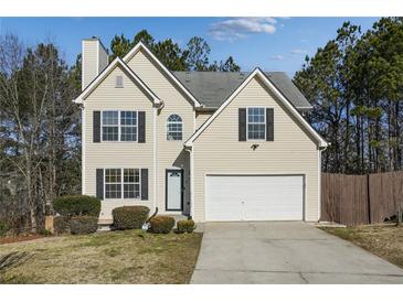 Two-story house with attached garage and landscaped yard at 6738 Merrywood Dr, Fairburn, GA 30213