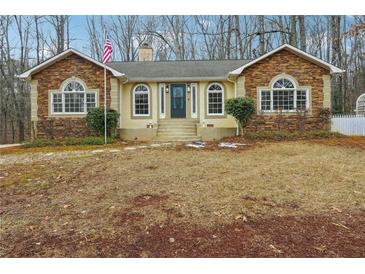 Ranch home with stone accents and a landscaped yard at 332 Stonecutters Cv, Stockbridge, GA 30281