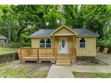 Charming exterior view of a small, yellow, one-story home with a new deck and well-maintained landscaping at 2064 Chicago Nw Ave, Atlanta, GA 30314