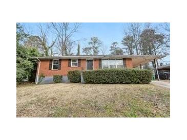 Brick ranch house with a well-maintained lawn and shrubs at 1820 Arkose Dr, Atlanta, GA 30316