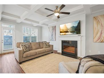 Bright living room featuring a coffered ceiling, fireplace, large windows, and comfortable seating at 86 Trailview Ln, Hiram, GA 30141