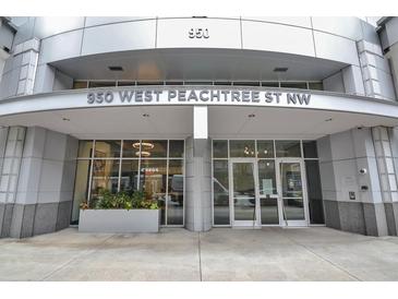 Modern building exterior at 950 West Peachtree St NW with glass doors and a landscaped planter at 950 W Peachtree Nw St # 904, Atlanta, GA 30309