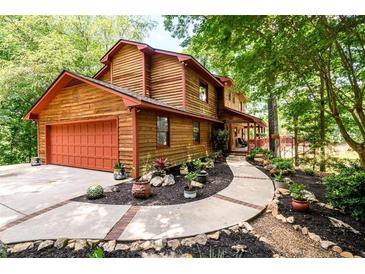 Two story home with wood siding, red door and walkway at 4955 H D Atha Rd, Covington, GA 30014
