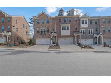 Brick front exterior of a three-story townhome with two-car garage at 3179 Clairebrooke Ave, Atlanta, GA 30341