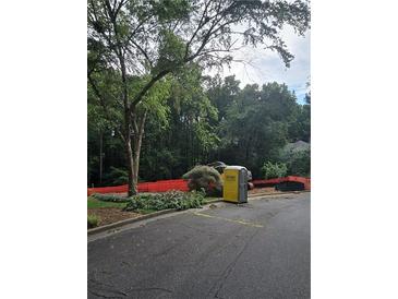 Construction site with portable toilet and heavy equipment surrounded by orange safety fencing and trees at 3910 W Cooper Lake Se Dr, Smyrna, GA 30082