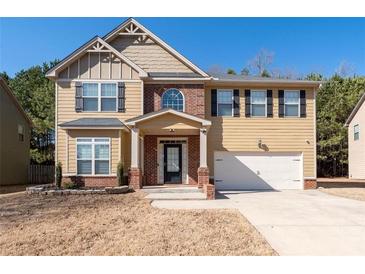 Two story house with brick and siding, two car garage, and landscaping at 313 Pennant Ln, Fairburn, GA 30213