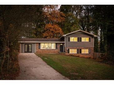 Two-story house with gray siding, brick accents, and a landscaped yard at 3512 Casa Woods Ln, Clarkston, GA 30021