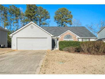 White house with a two-car garage and manicured lawn at 1013 Bluecoat Cir, Hampton, GA 30228