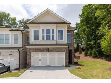 Brick front of charming two-story home with attached two-car garage and landscaped lawn at 1442 Casteel Lake Ln # 277, Buford, GA 30518