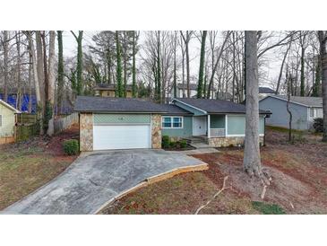 Ranch style home with attached garage and stone accents at 1606 Fieldgreen Overlook, Stone Mountain, GA 30088