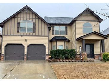 Charming two-story home with a two-car garage and a welcoming front porch at 1370 Long Acre Dr, Loganville, GA 30052