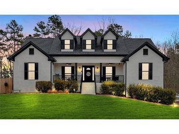 Stunning two-story home with white brick exterior, black accents, and a manicured lawn at 65 Centerport Dr, White, GA 30184