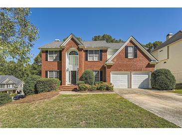 Brick two-story house with a two-car garage and landscaped lawn at 3314 Mill Grove Ter, Dacula, GA 30019