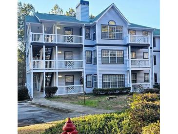 Two-story building with light blue siding, balconies, and landscaping at 3526 Shepherds Path # 1, Decatur, GA 30034