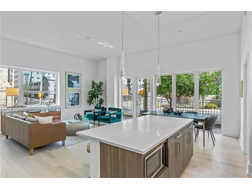 Open concept kitchen and living area with island, modern appliances, and hardwood floors at 775 Juniper Ne St # 103, Atlanta, GA 30308