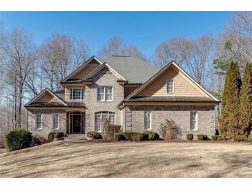 Charming gray brick two-story home with lush front lawn, mature trees, and elegant architectural details at 305 Glengarry Chase, Covington, GA 30014