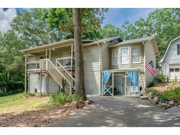 Charming multi-level home with covered parking and an American flag displayed at 4297 Earney Rd, Woodstock, GA 30188