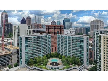 Aerial view of a modern apartment building with a pool and city skyline in the background at 44 Peachtree Nw Pl # 1828, Atlanta, GA 30309