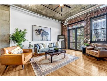 Spacious living room with exposed brick, modern furniture, and plenty of natural light at 3180 Mathieson Ne Dr # 703, Atlanta, GA 30305