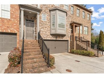 Brick front exterior of townhome with 2-car garage and staircase at 2671 Willow Field Se Xing # 14, Marietta, GA 30067