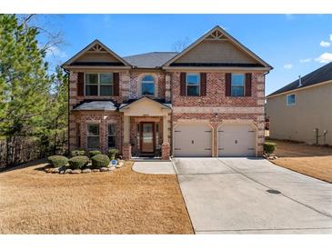 Brick two-story house with a two-car garage and manicured lawn at 1662 Indian Woods Rd, Lithonia, GA 30058