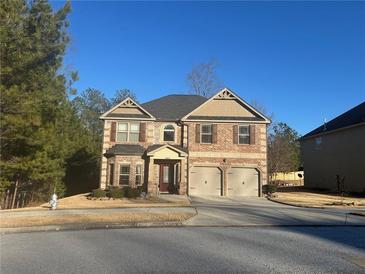 Two-story brick home with three-car garage and landscaped yard at 1662 Indian Woods Rd, Lithonia, GA 30058