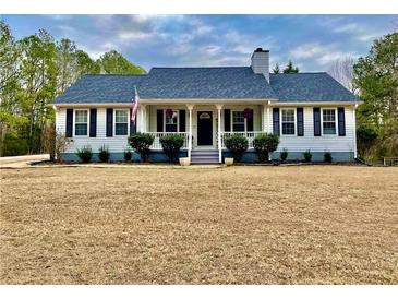 White house with gray roof, porch, and landscaping; American flag at 4320 Center Hill Church Rd, Loganville, GA 30052