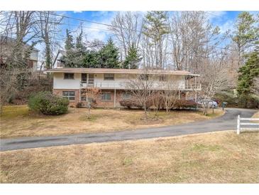 Two-story brick home with a long driveway and mature trees at 1036 Wooten Lake Nw Rd, Kennesaw, GA 30144