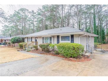 Charming single-story home featuring a brick facade, manicured shrubs, and a well-maintained front yard at 2534 Ben Hill Rd, Atlanta, GA 30344