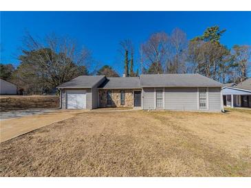 Ranch style home with gray siding, stone accents, and attached garage at 5725 Twain Dr, Ellenwood, GA 30294