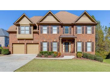 Brick two-story house with a three-car garage and landscaped lawn at 1400 Cresthaven Ln, Lawrenceville, GA 30043