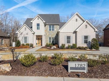Two-story home with white brick, gray shutters, and landscaping at 1782 Patrick Rd, Dacula, GA 30019