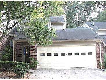 Two-story brick home featuring a two-car garage with multi-paneled doors and a covered entrance at 5 Belmonte Sw Ct, Atlanta, GA 30311