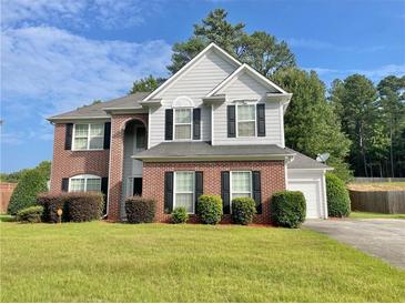 Two-story brick home with gray siding, landscaped lawn, and attached garage at 4126 Mcbride Dr, Powder Springs, GA 30127
