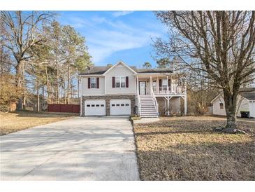 Charming two-story home with attached two-car garage and inviting elevated porch and a long concrete driveway at 118 Gilberts Way, Temple, GA 30179