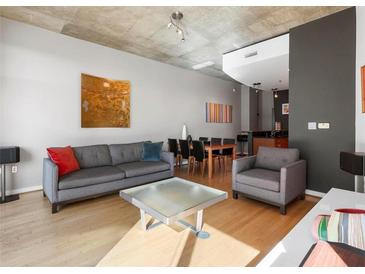 Bright living room features hardwood floors, gray sofa, and a spacious layout at 943 Peachtree Ne St # 902, Atlanta, GA 30309