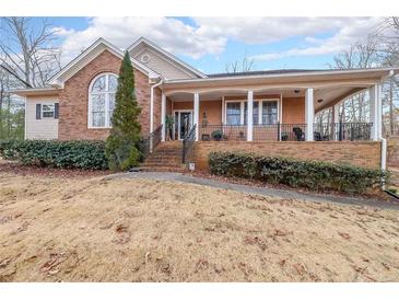 Brick ranch house with a large front porch and landscaped yard at 9545 Grande Dr, Winston, GA 30187