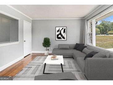 Cozy living room with a large window and gray sectional sofa is perfect for relaxation at 3453 Eisenhower E Cir, Atlanta, GA 30354