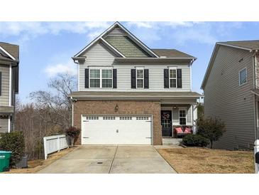 Two-story brick home with a white garage door and a landscaped yard at 135 Cessna Dr, Canton, GA 30114