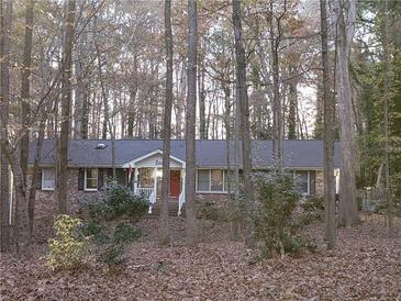 Charming brick home nestled among trees with a welcoming red door and a cozy front porch at 730 Ponderosa Ct, Fayetteville, GA 30214