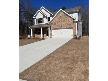 Beautiful two-story home with a brick facade and a spacious driveway at 2180 Highridge Point Dr, Lithia Springs, GA 30122