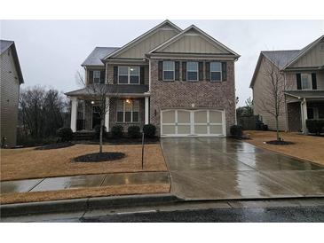 Two-story brick home with a three-car garage and landscaped yard at 2368 Misty Ivy Ct, Buford, GA 30519