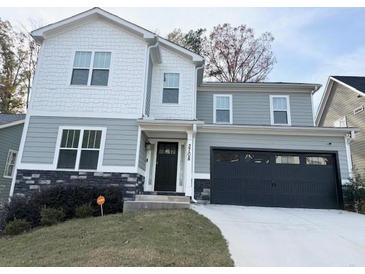 Two-story house with gray and white siding, a black garage door, and landscaping at 2708 Eagles Crest Ln, Decatur, GA 30034