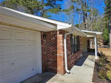 Charming brick home featuring a convenient one-car garage and inviting covered entrance at 432 Independence Dr, Jonesboro, GA 30238