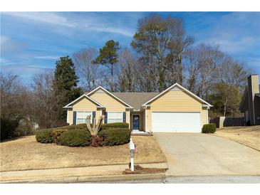 Ranch style home with attached garage, manicured lawn, and mature trees at 752 Bostonian Way, Lawrenceville, GA 30046
