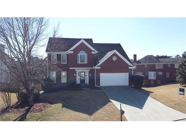 Charming two-story brick home with well-maintained lawn and attached two car garage in a suburban neighborhood at 3226 Masters Pass Ln, Snellville, GA 30039