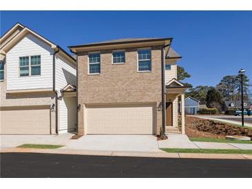 Brick front exterior of a two-story townhome with a two-car garage at 4101 Fulson Dr, Lilburn, GA 30047