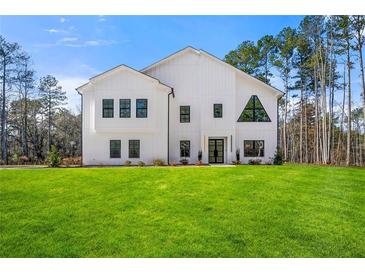 Stunning modern farmhouse exterior boasts a spacious lawn and pristine landscaping at 130 Wesley Place, Fayetteville, GA 30214