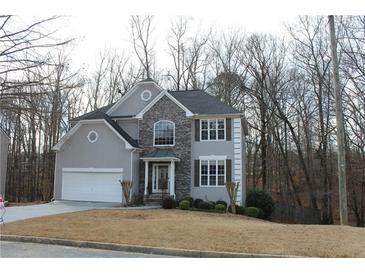 Two-story house with gray siding, stone accents, and a white garage door at 355 Holland Springs Way, Powder Springs, GA 30127