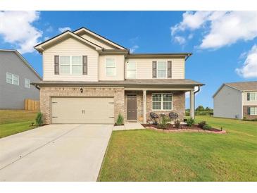 Two-story house with a neutral color scheme and a landscaped lawn at 8819 Sibella Ct, Lithia Springs, GA 30122